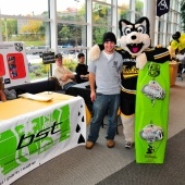 Blizzard T. Husky and a student standing with a bright green snowboard.